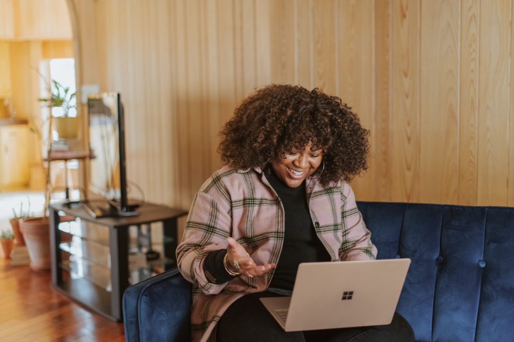 Woman on computer call with friends to celebrate Friendsgiving