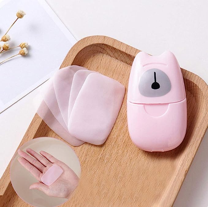 Wooden tray holding pink dispenser for paper soap sheets